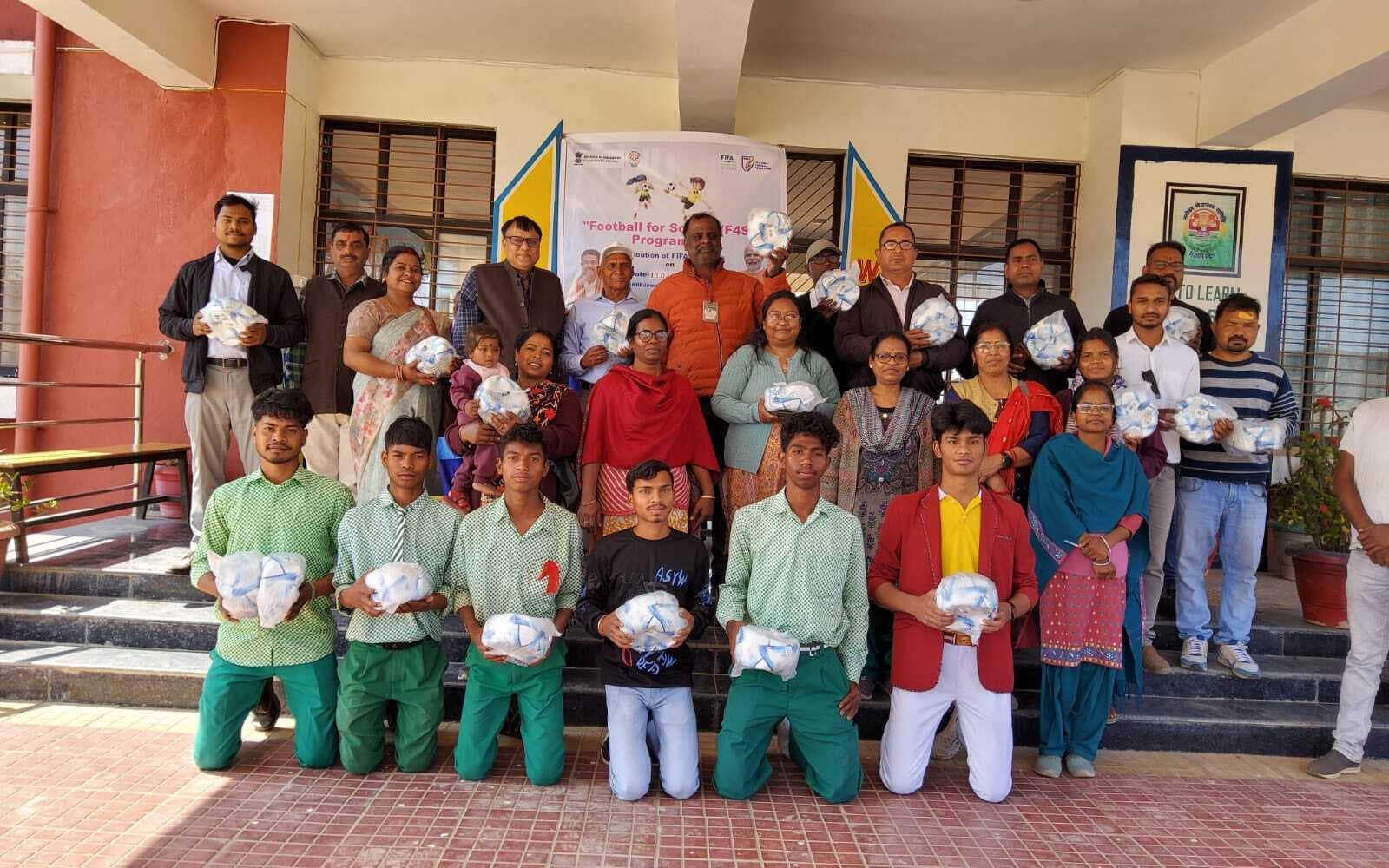 खिलाड़ियों के बीच फुटबॉल का वितरण