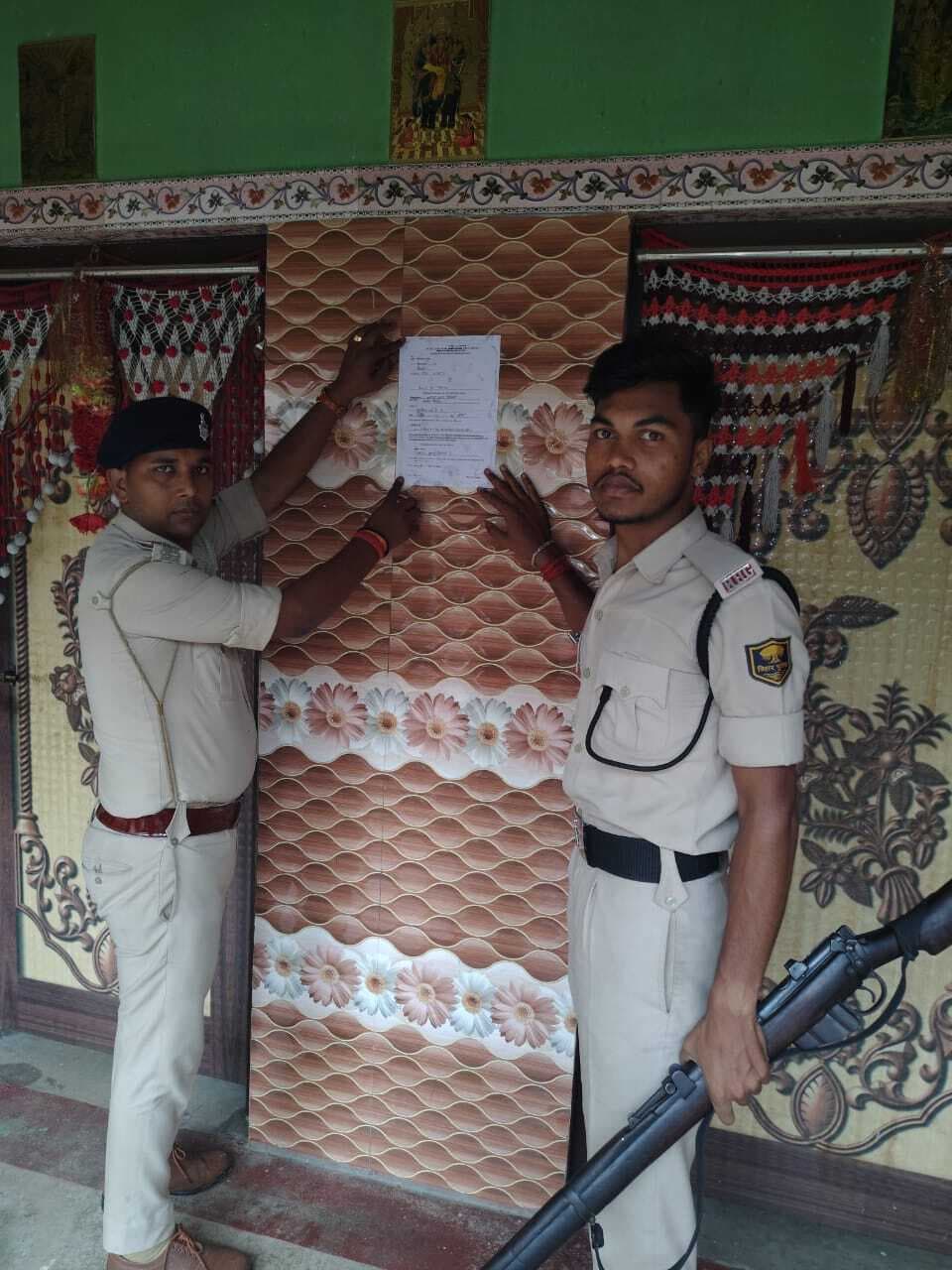 दुष्कर्म व छिनतई के मामले में फरार अभियुक्त के घर पुलिस ने चिपकाया इश्तेहार