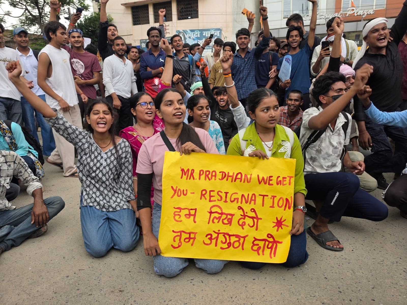बैनर लेकर सड़क पर बैठे छात्र