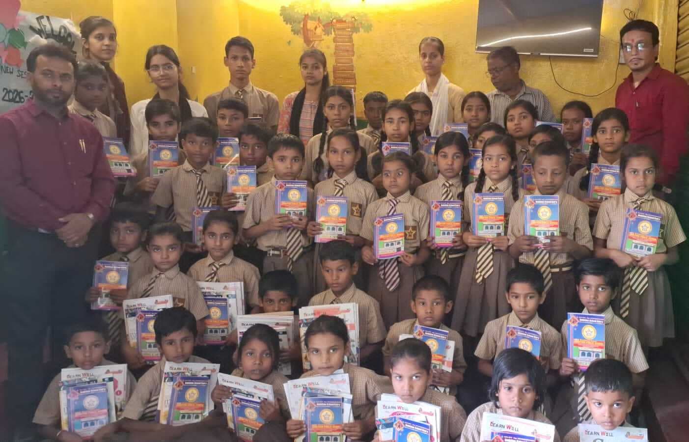 न्यू एम्बिशन स्कूल में बच्चों को दी गयी पुस्तक