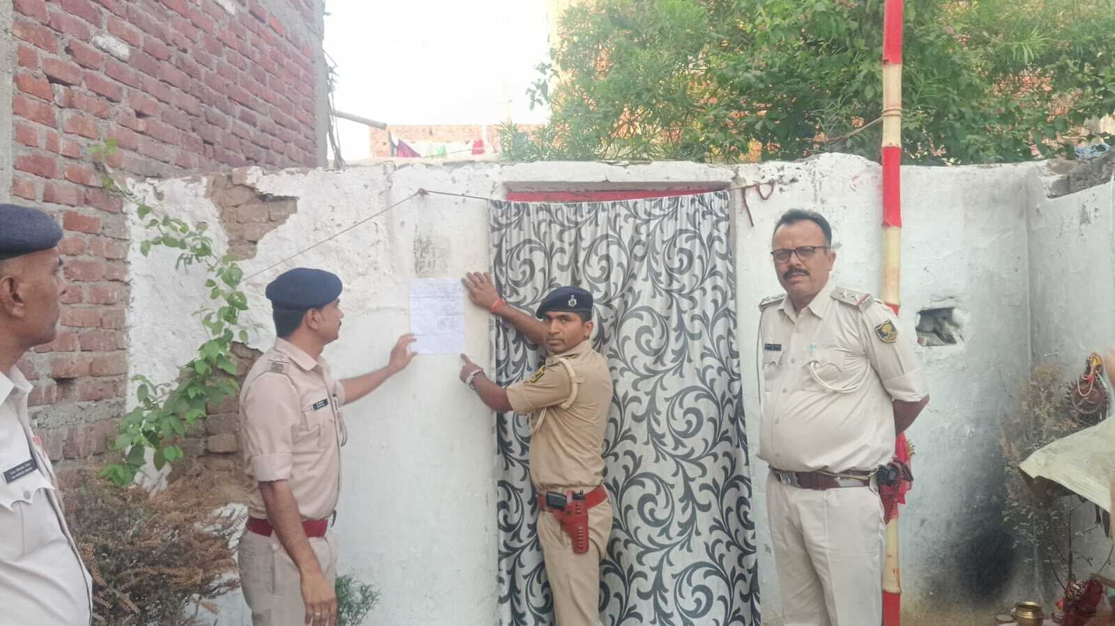 गोलीकांड में फरार आरोपित के घर पर चिपकाया इश्तेहार