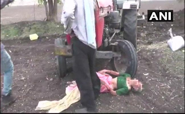 जमीनी विवाद के कारण बेटे ने अपनी मां को एक ट्रैक्टर के सामने फेंका