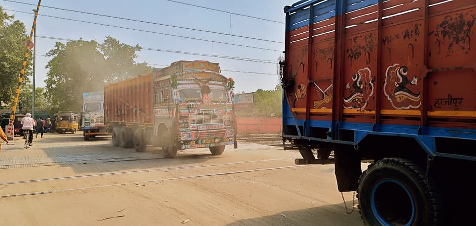 बिना ढके बालू लदे ट्रकों का परिचालन होने से यात्रियों व दुकानदारों का हो रहा है बुरा हाल