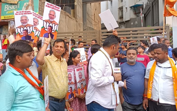 PHOTOS: पीएम मोदी के रोड शो को लेकर लोगों में उत्साह, इंतजार में सड़कों पर तख्तियां लेकर खड़े लोग