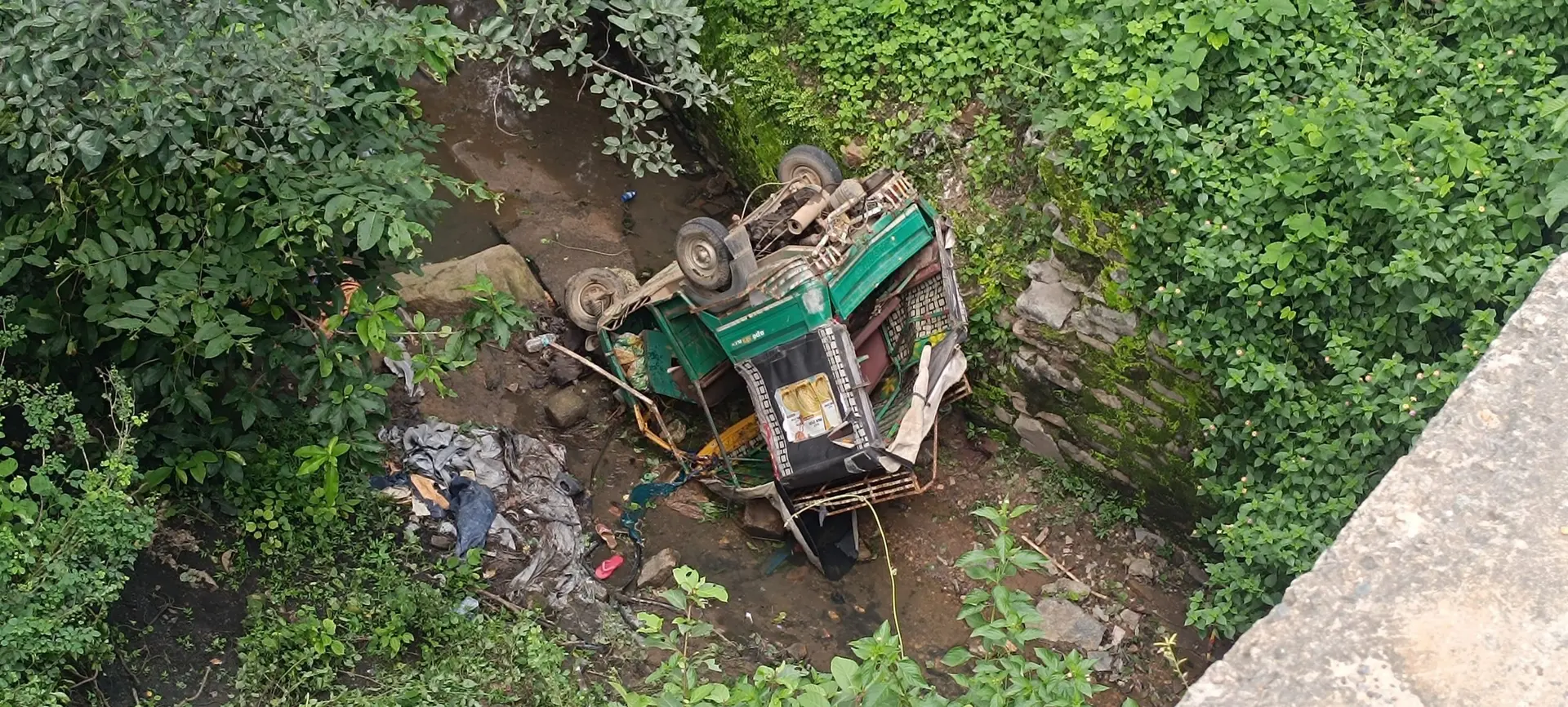 कंटेनर की टक्कर से 20 फीट नीचे खाई में गिरा ऑटो, बच्ची की मौत, 14 घायल