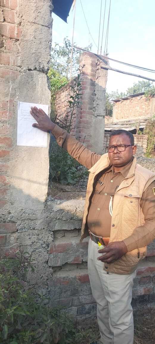 फरार वारंटी के घर पुलिस ने चिपकाया इश्तेहार