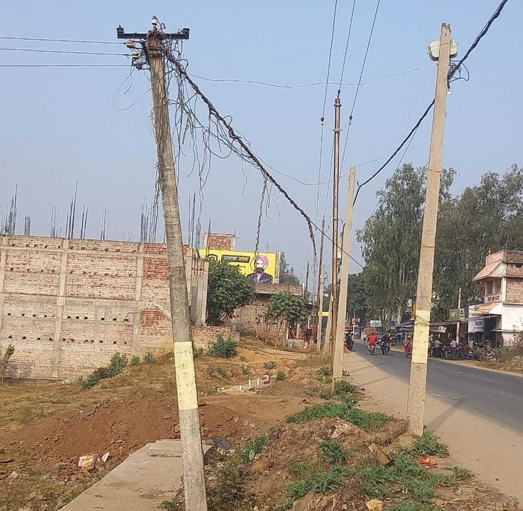सड़क किनारे झुका बीजली का पोल