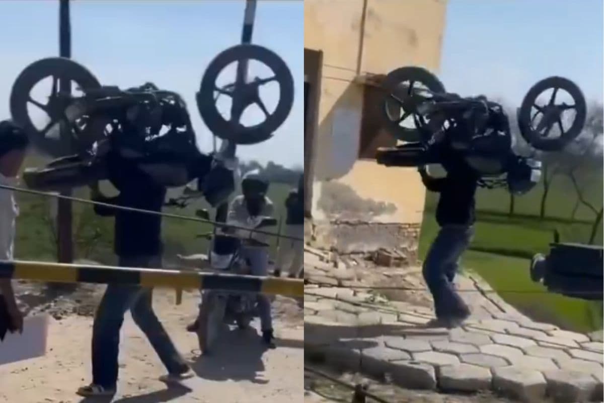 Viral Video: वाह रे इंसान! कंधे पर बाइक उठा रेलवे फाटक किया पार, देखें वीडियो