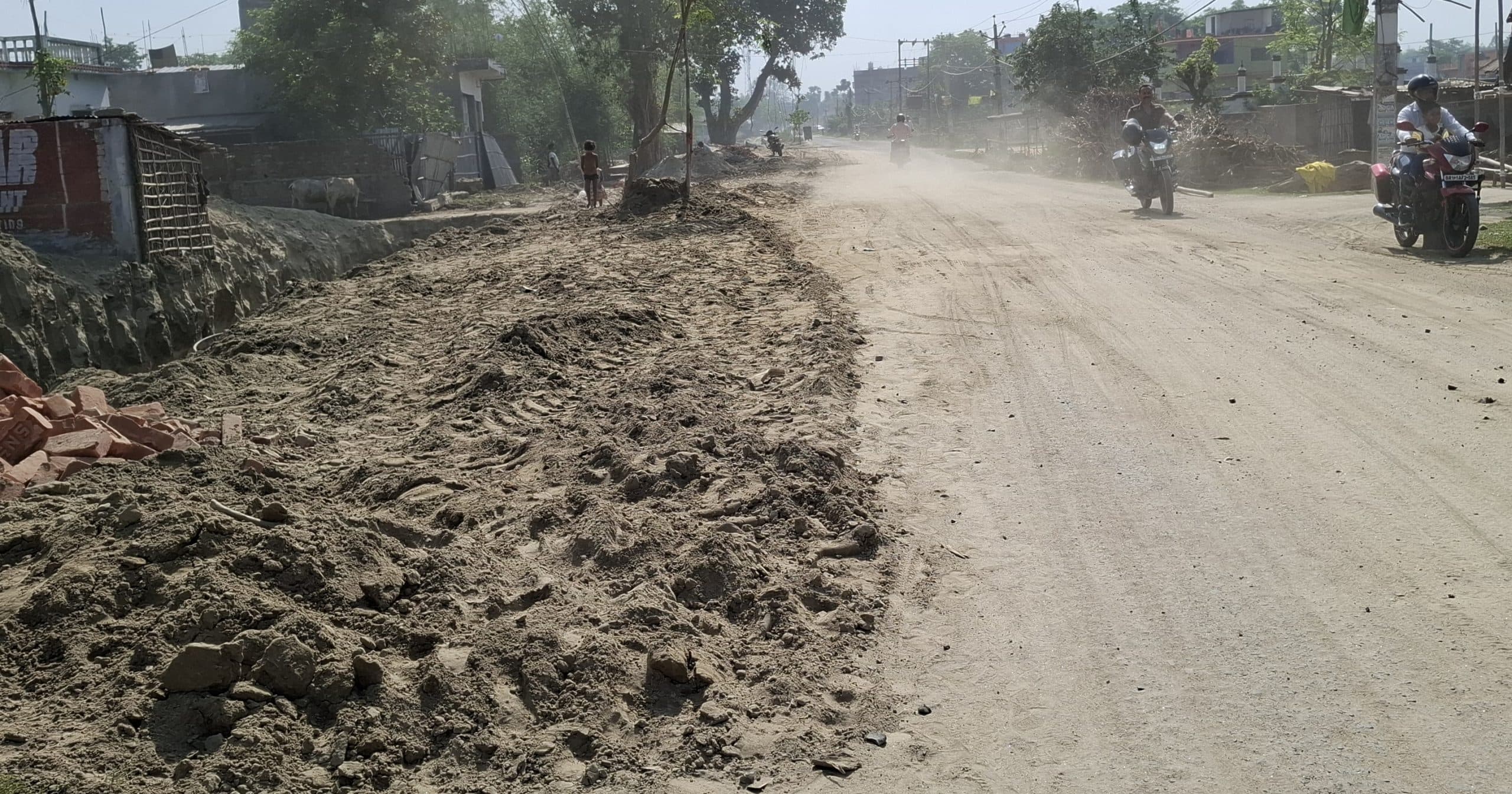 नाला निर्माण के लिए मिट्टी खोद सड़क पर रखा, आंखों को आहत कर रही धूल