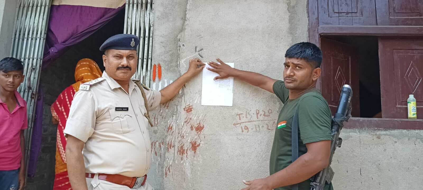 पुलिस ने दो फरार आरोपितों के घर चिपकाया इश्तेहार