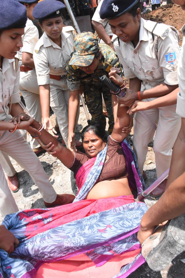 Dhanbad News : जेसीबी के सामने लेटकर महिलाओं ने किया एसएनएमएमसीएच में चहारदीवारी निर्माण का विरोध, पुलिस व ग्रामीणों में नोकझोंक