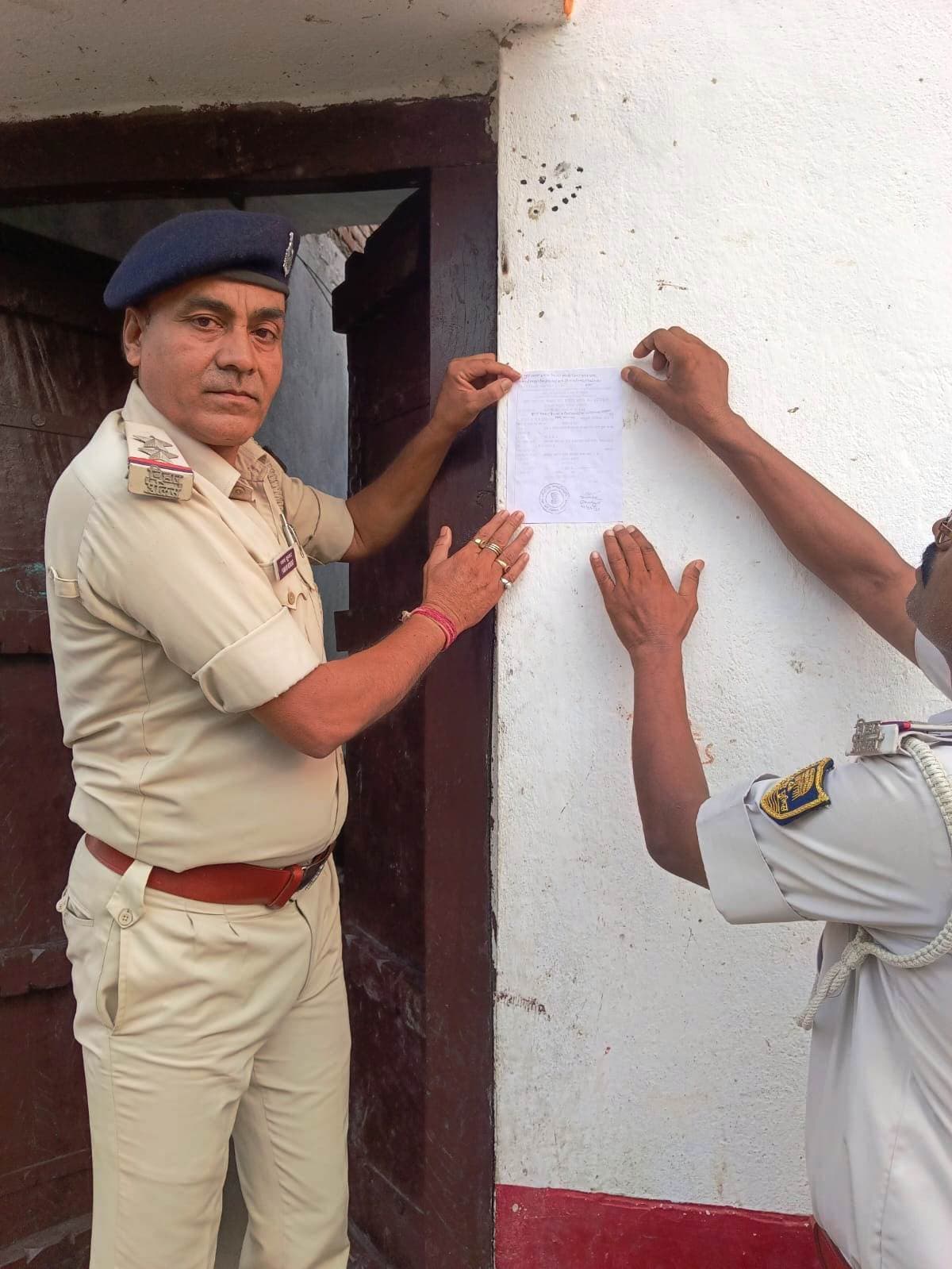 चनहट गांव में अभियुक्तों के घर पुलिस ने चिपकाया इश्तेहार
