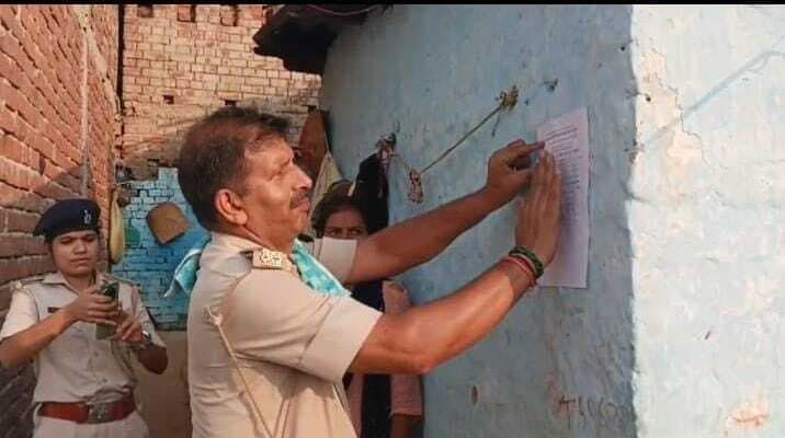 नवाबगंज गांव में हत्या मामले के फरार चार अभियुक्तों के घर पुलिस ने चिपकाये इश्तेहार