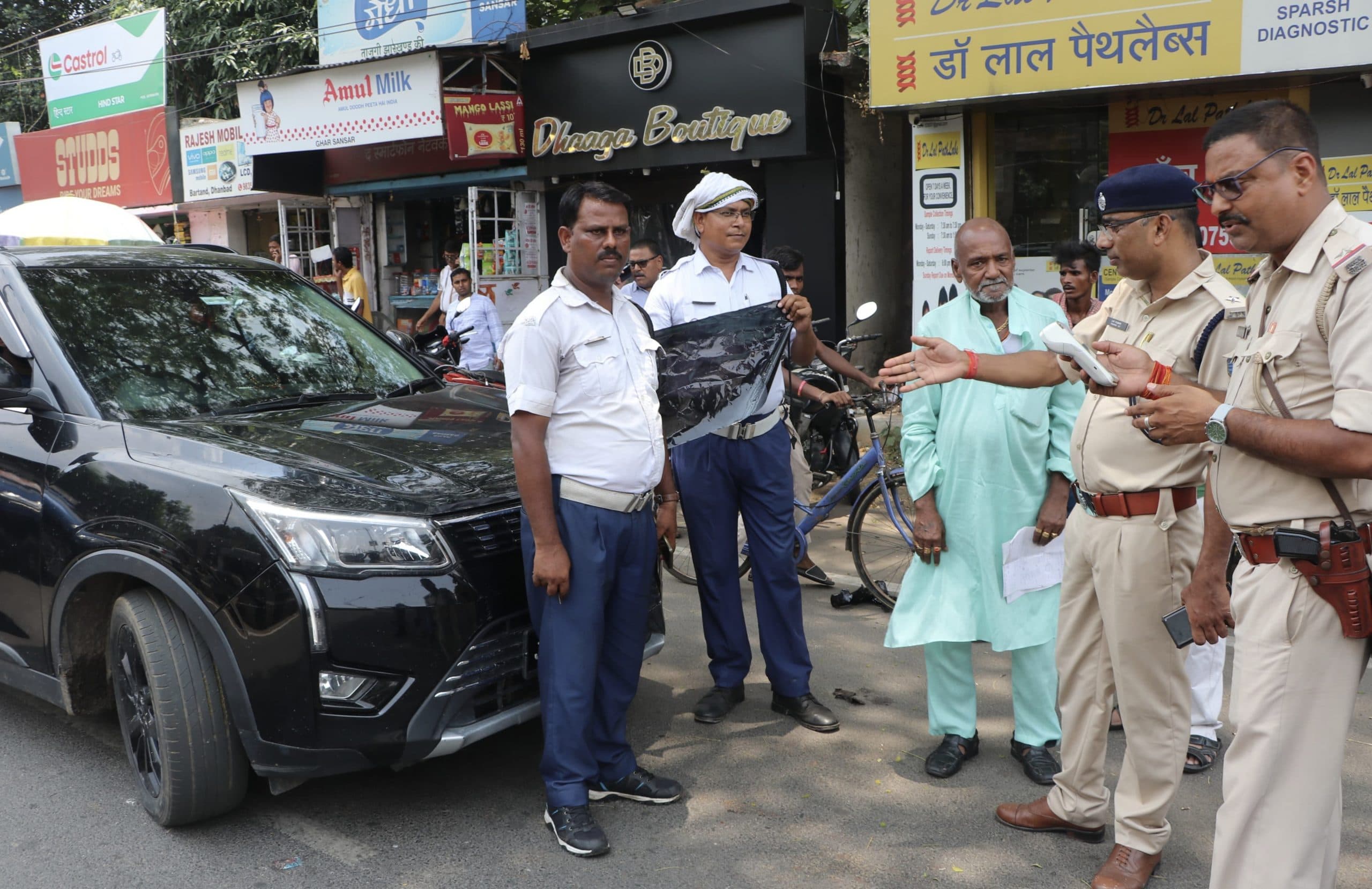 Dhanbad News: वाहन जांच में दर्जनों वाहनों के काले शीशे उतारे गये