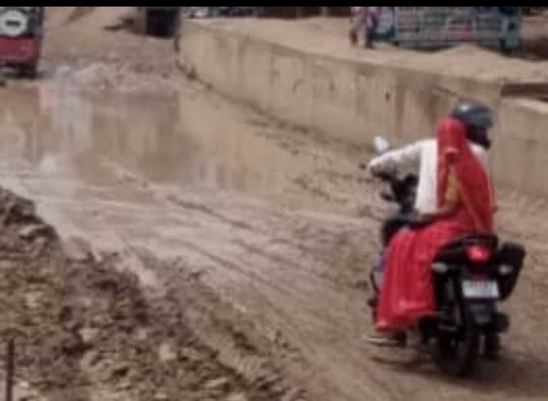 कीचड़युक्त सर्विस सड़क पर जान जोखिम में डालकर चल रहे लोग