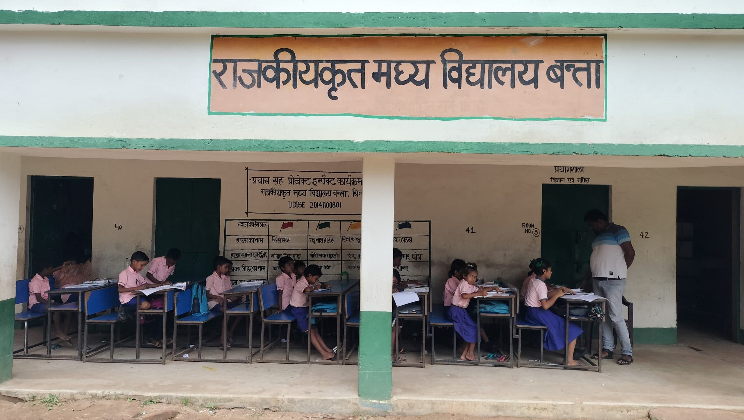 बरामदे में बैठकर पढ़ाई करते हैं विद्यार्थी