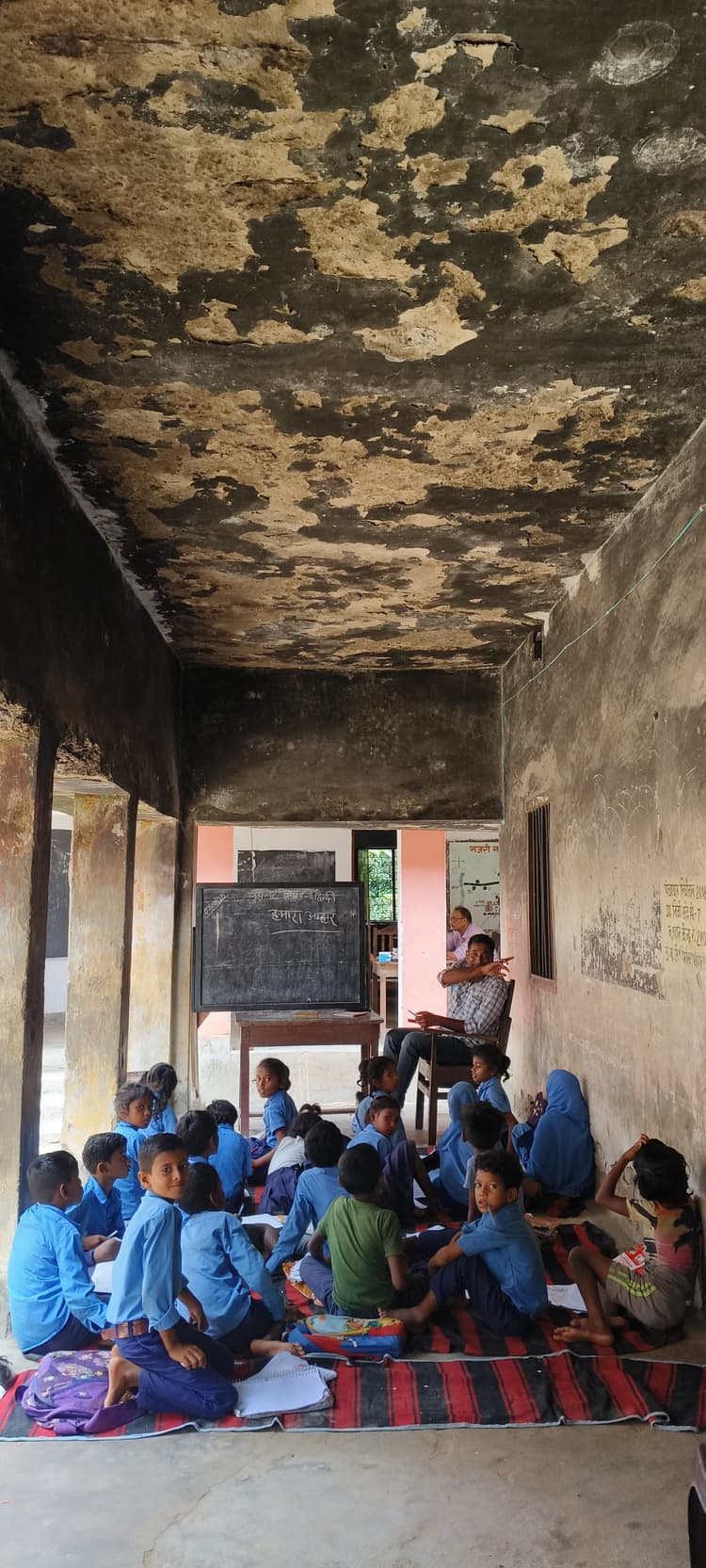 जर्जर भवन के नीचे पढ़ रहे बच्चे, हादसे की आशंका से सहमे हैं अभिभावक