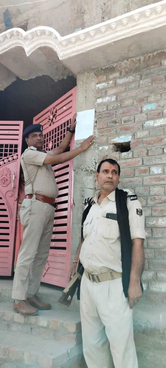 कोर्ट के आदेश पर एससी-एसटी थाना पुलिस ने फरार आरोपित के घर चिपकाया इश्तेहार