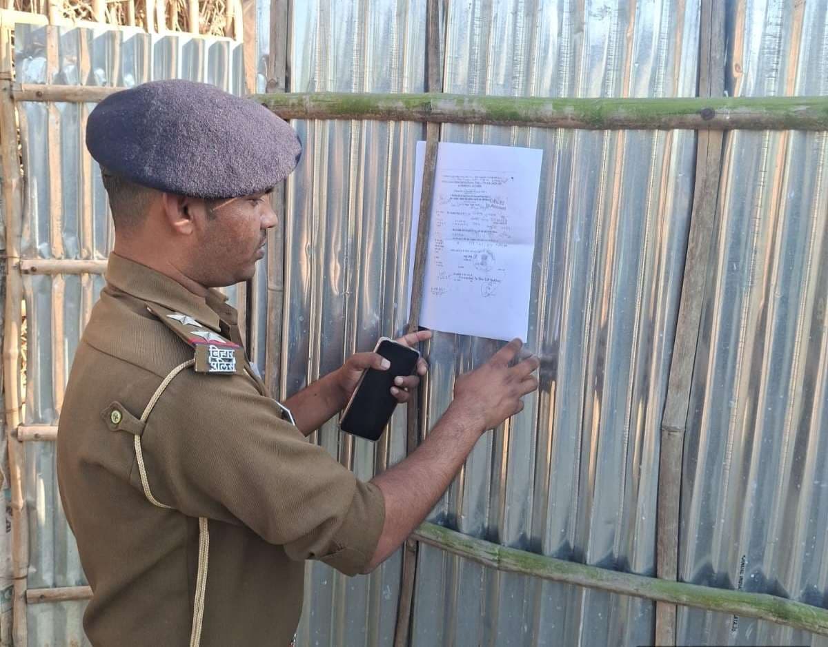 पुलिस ने फरार वारंटी के घर इश्तेहार चस्पा किया