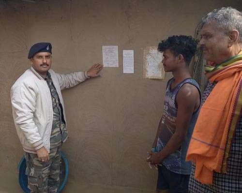 फरार अभियुक्त के घर चिपकाया इश्तेहार