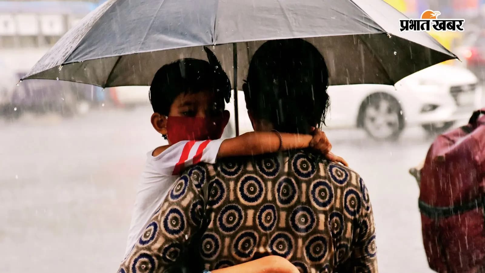 भारी वर्षा के बीच अपने बच्चे को स्कूल छोड़ने जाती महिला. भारी वर्षा के बीच अपने बच्चे को स्कूल छोड़ने जाती महिला.
