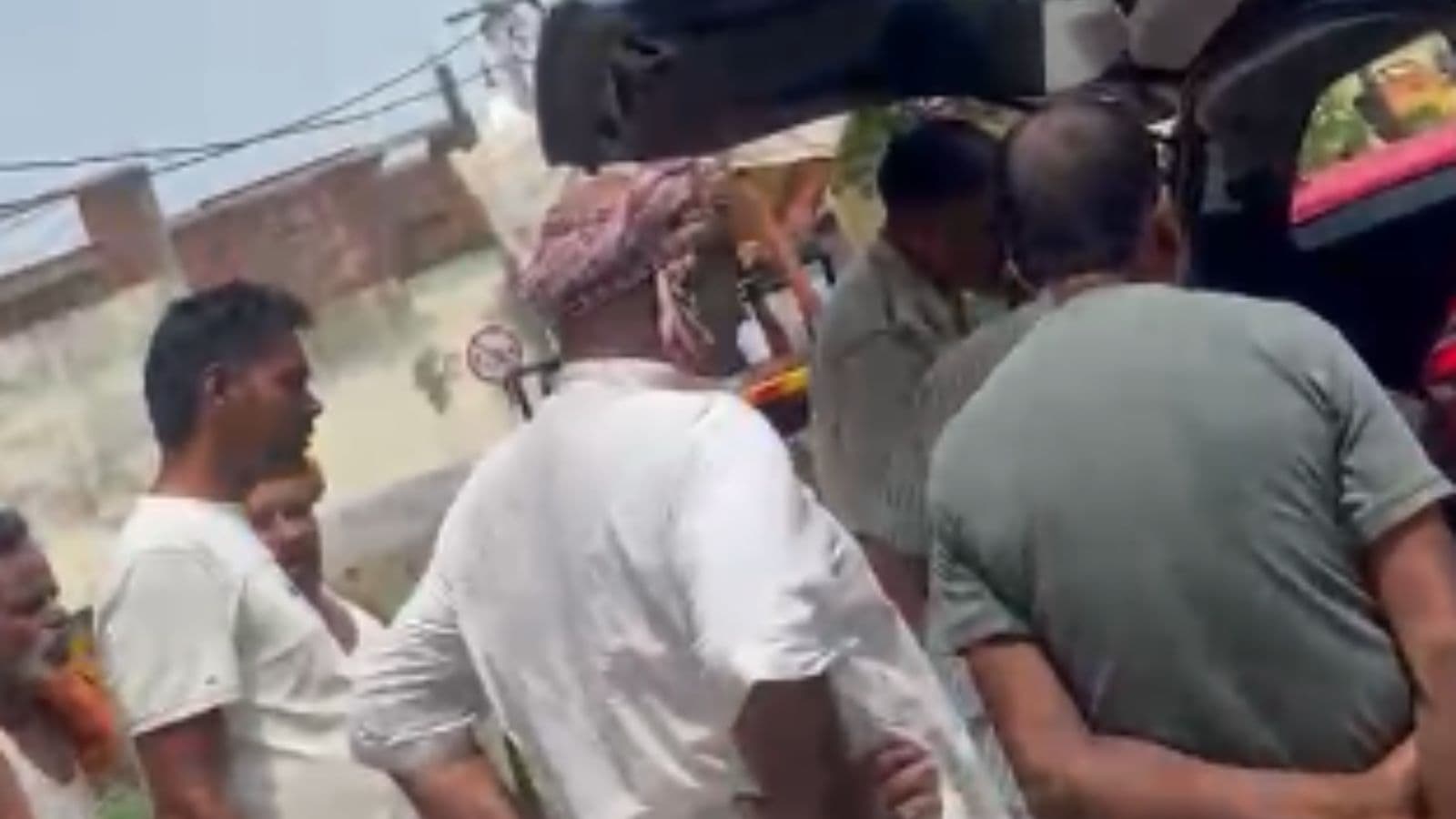 क्षतिग्रस्त कार को देखते ग्रामीण