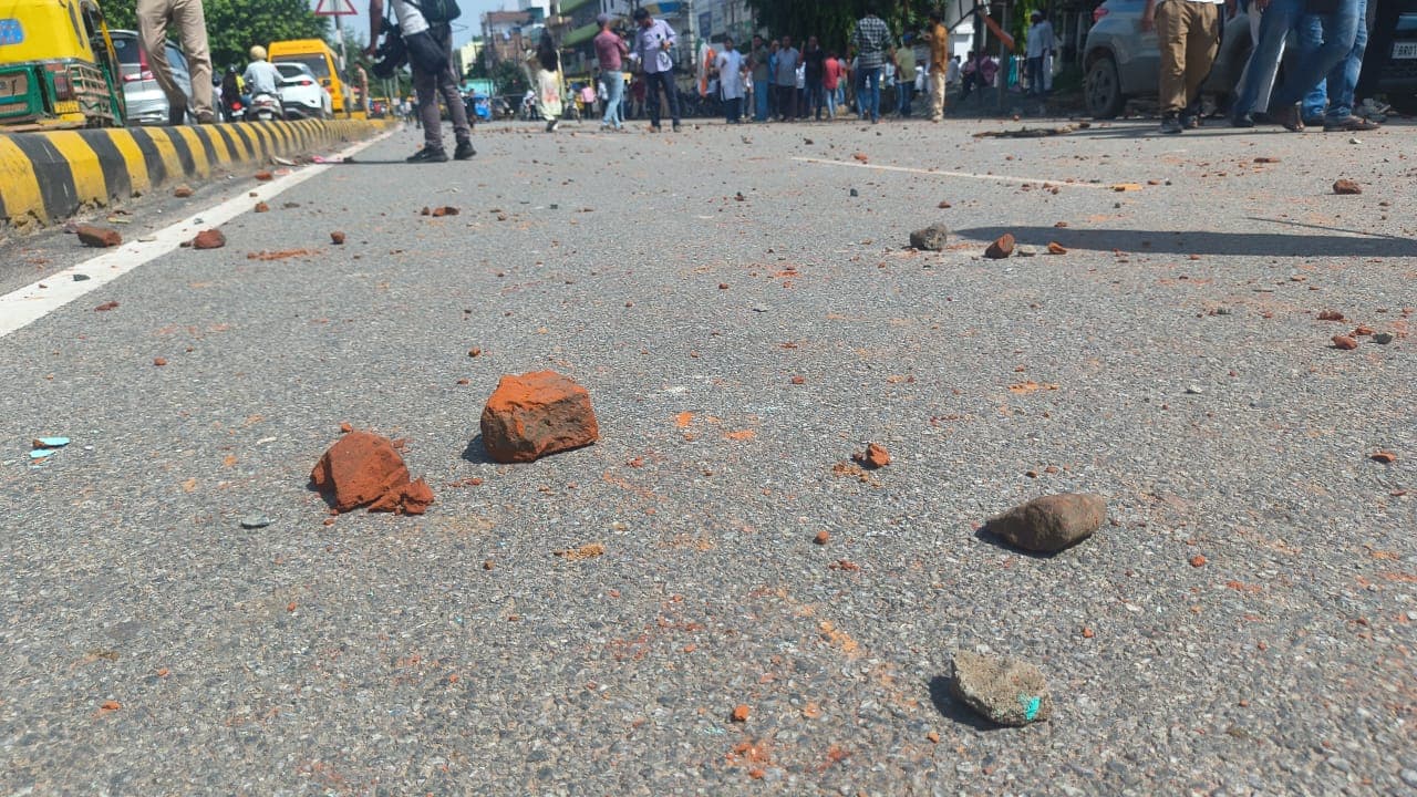 सदाकत आश्रम के बाहर झड़प के बाद सड़क पर बिखरे पत्थर