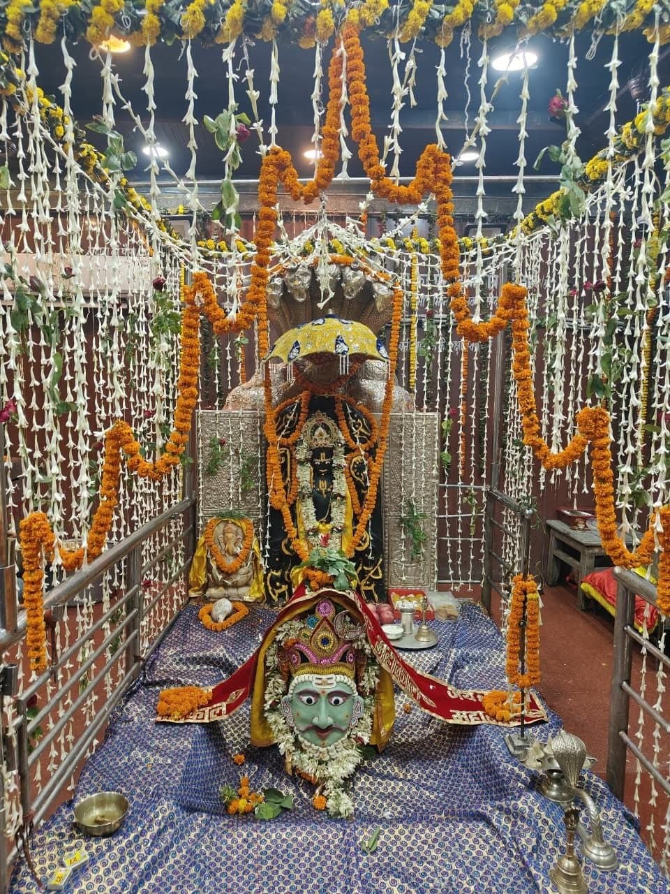 भगवान शिव के शिवलिंग को हरे रंग का एक बेहद सुंदर और शांत मुखौटा से सुसज्जित किया गया है. जिस पर लाल 'जय महाकाल' लिखा वस्त्र और फूलों की मालाएं लिपटी हुई हैं. इसके ठीक पीछे नाग-छत्र के साथ मुख्य विग्रह और चारों तरफ छत से लटकती सफेद व गेंदे के फूलों की अनगिनत लड़ियों की अलौकिक सजावट पूरे परिवेश को अत्यंत पवित्र और भक्तिमय बना रही है.