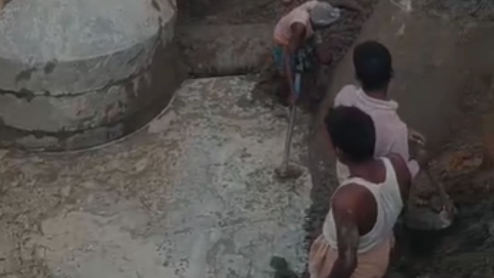 धंसी सड़क के अंदर उतरकर काम करते मजदूर